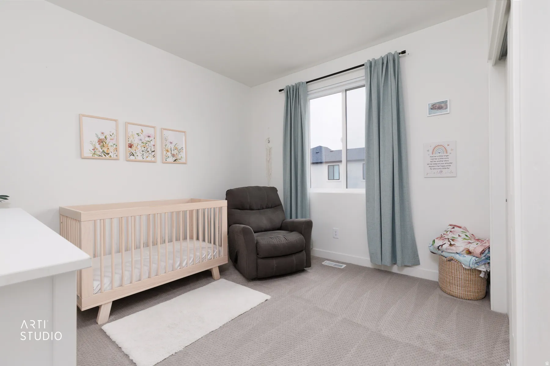Bedroom featuring a nursery area and light carpet