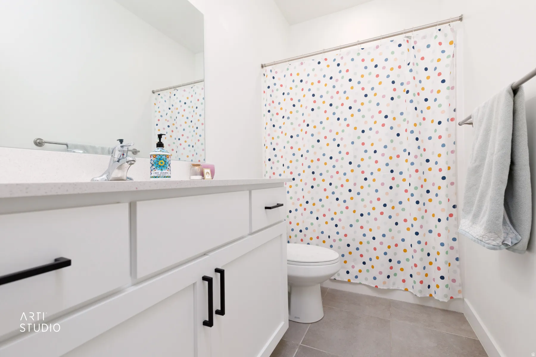Bathroom featuring curtained shower, vanity, and light tile patterned flooring