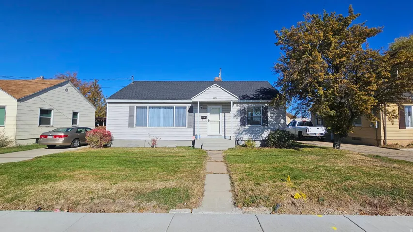 Bungalow featuring a front lawn and roof with shingles