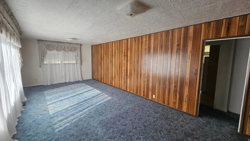 Family room with wooden paneling and dark colored carpet