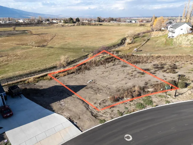 Aerial view of sparsely populated area with property boundaries highlighted and a mountain backdrop