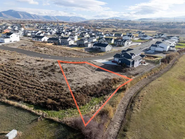 Aerial view of residential area with a mountain backdrop and property boundaries highlighted