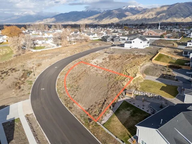 Aerial perspective of suburban area with property boundaries highlighted and a mountainous background