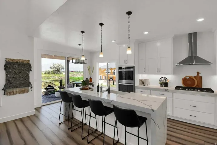 Kitchen with wall chimney range hood, white cabinetry, light stone countertops, a breakfast bar area, and recessed lighting