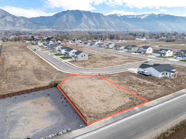 Aerial view of residential area with a mountain backdrop and property parcel outlined