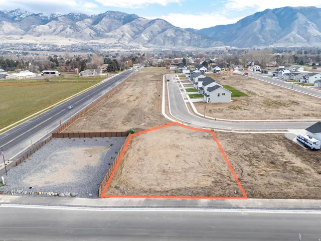 Aerial view of residential area with a mountain backdrop and property boundaries highlighted