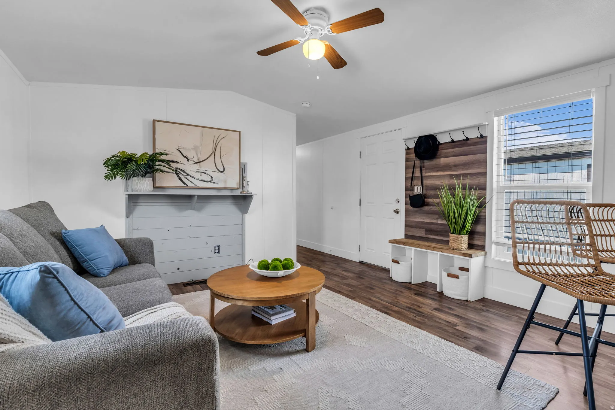 Living area featuring wood finished floors, a ceiling fan, and vaulted ceiling