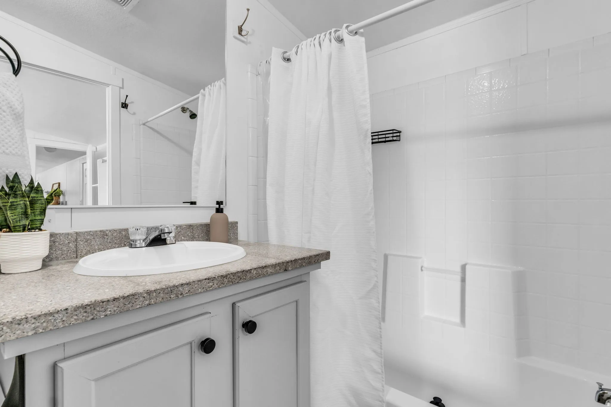 Full bathroom with shower / bath combo with shower curtain and vanity