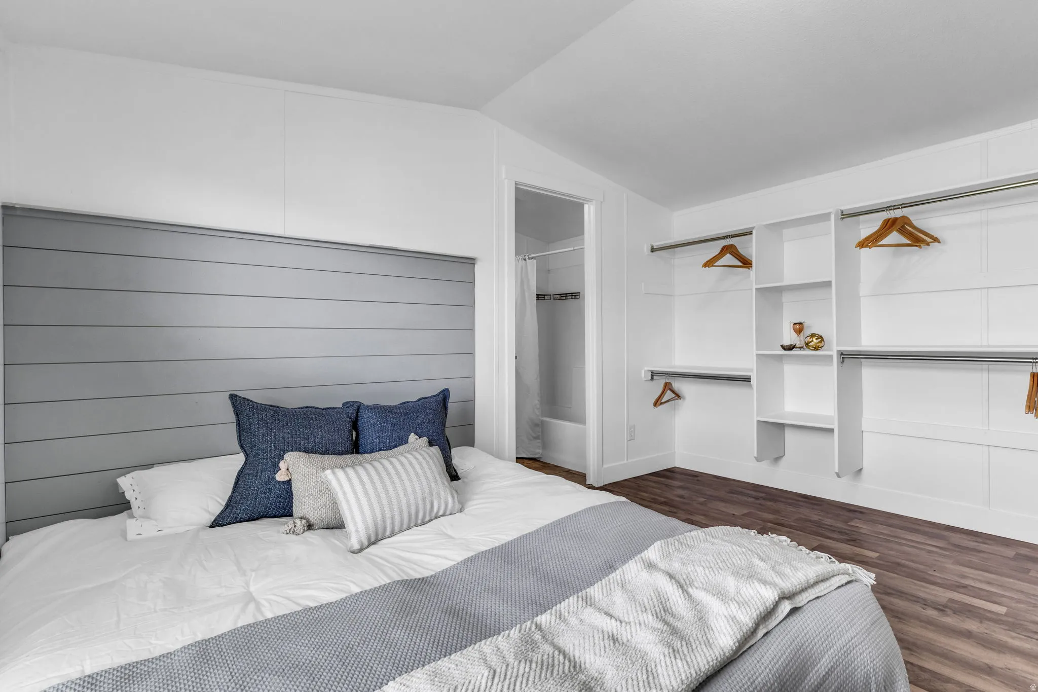 Bedroom with lofted ceiling and dark wood-style flooring