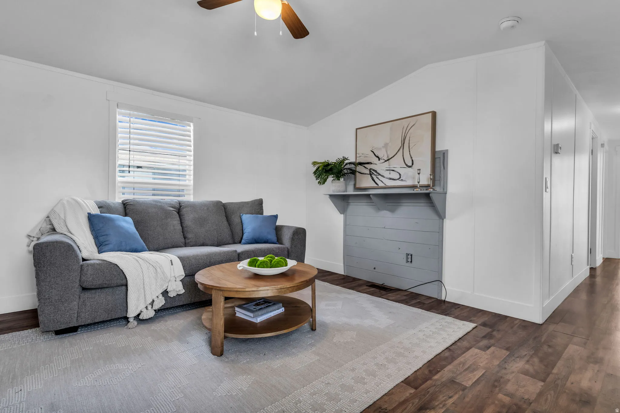 Living area with wood finished floors, lofted ceiling, and a ceiling fan