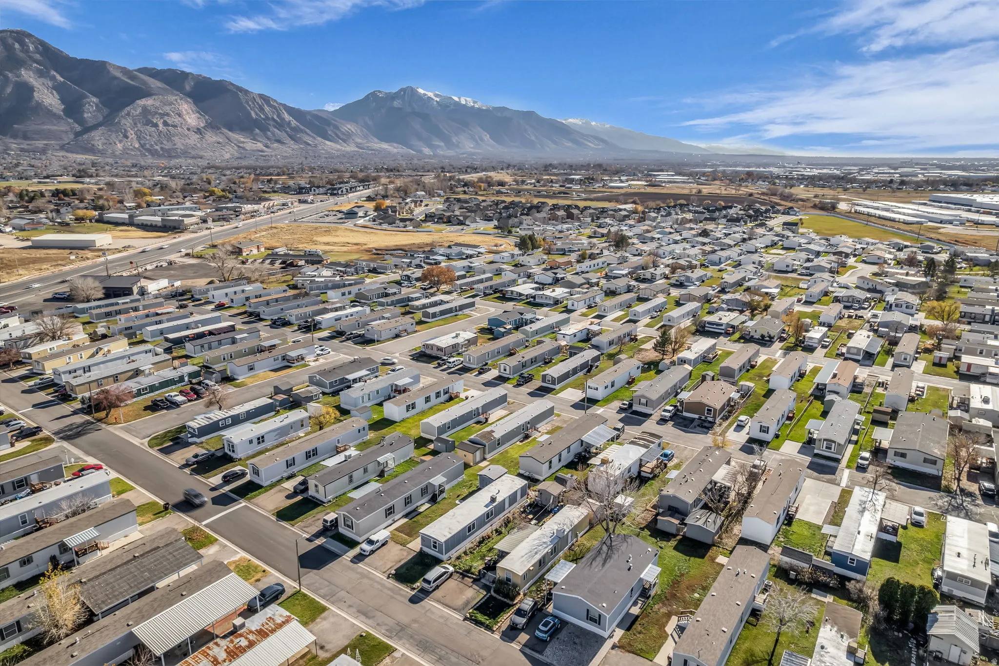 Aerial overview of property's location with nearby suburban area and a mountainous background