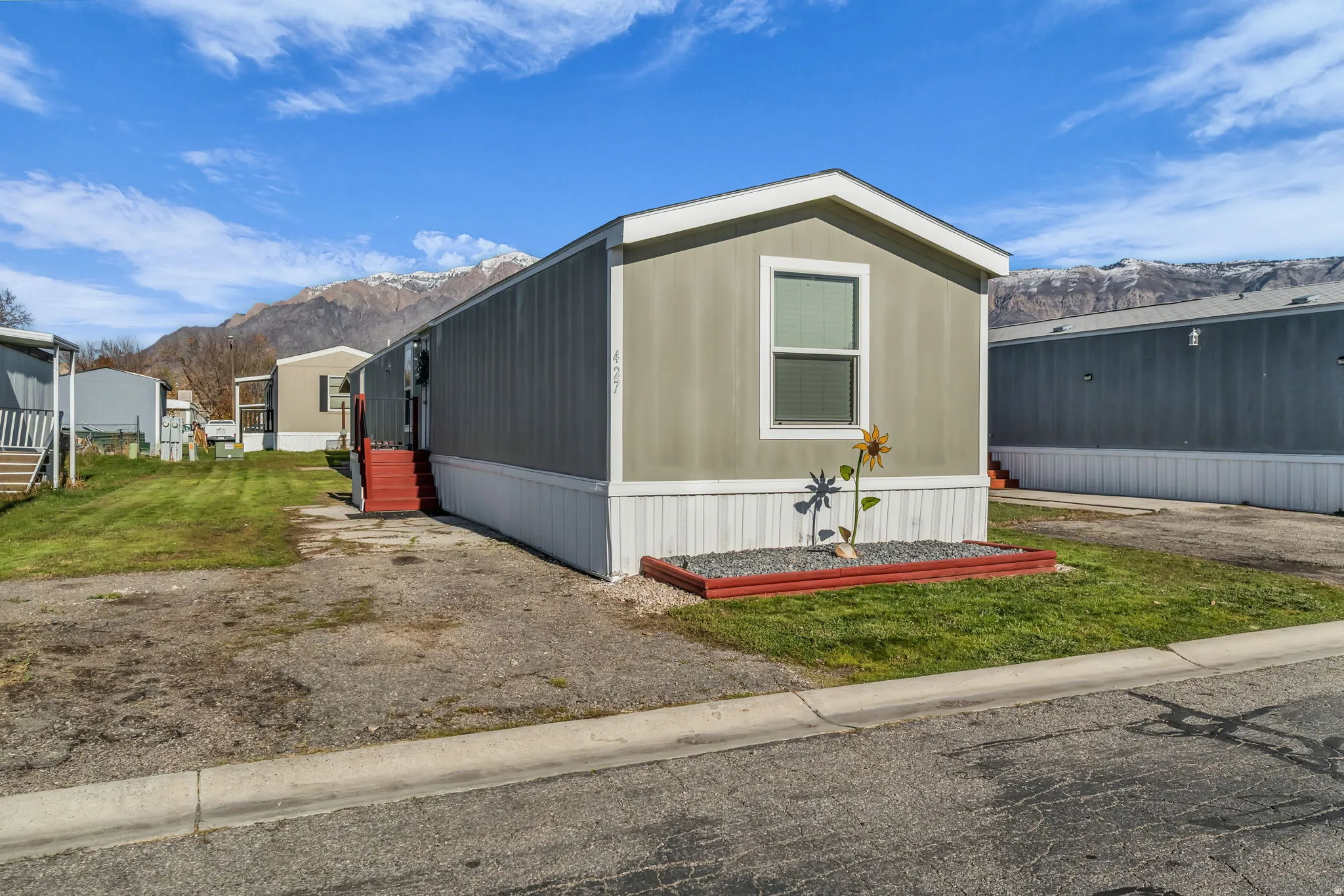 Manufactured / mobile home featuring a mountain view and a front lawn