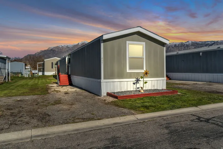 View of front of property with a mountain view and a yard