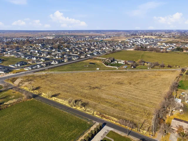 Aerial view of property and surrounding area featuring nearby suburban area