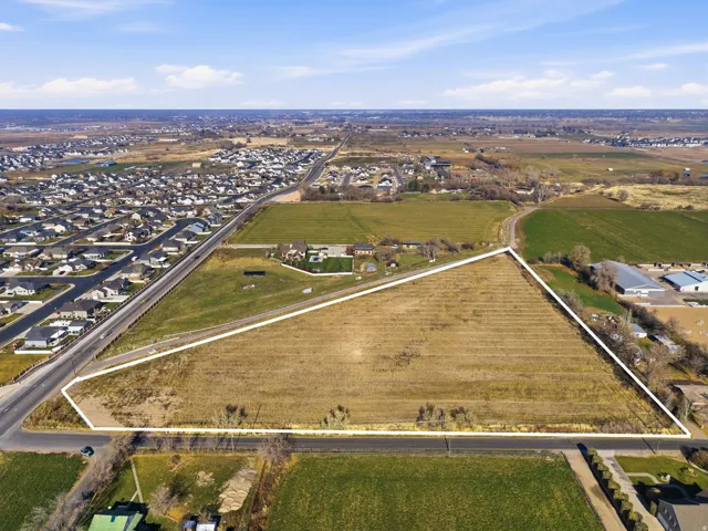 Aerial overview of property's location with property boundaries highlighted, rural landscape, and rows of crops