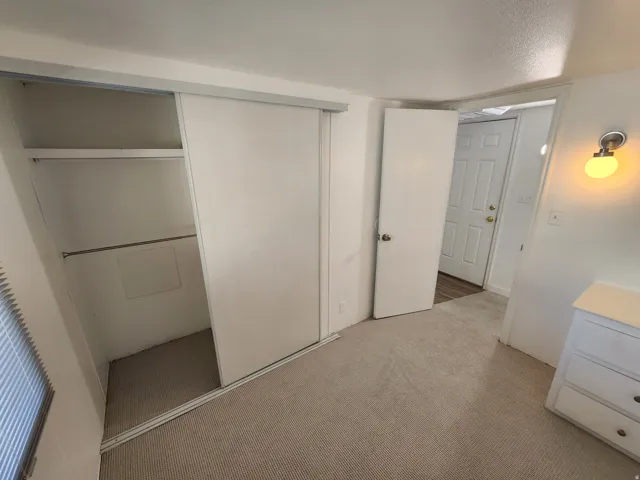 Unfurnished bedroom with a closet, light carpet, and a textured ceiling