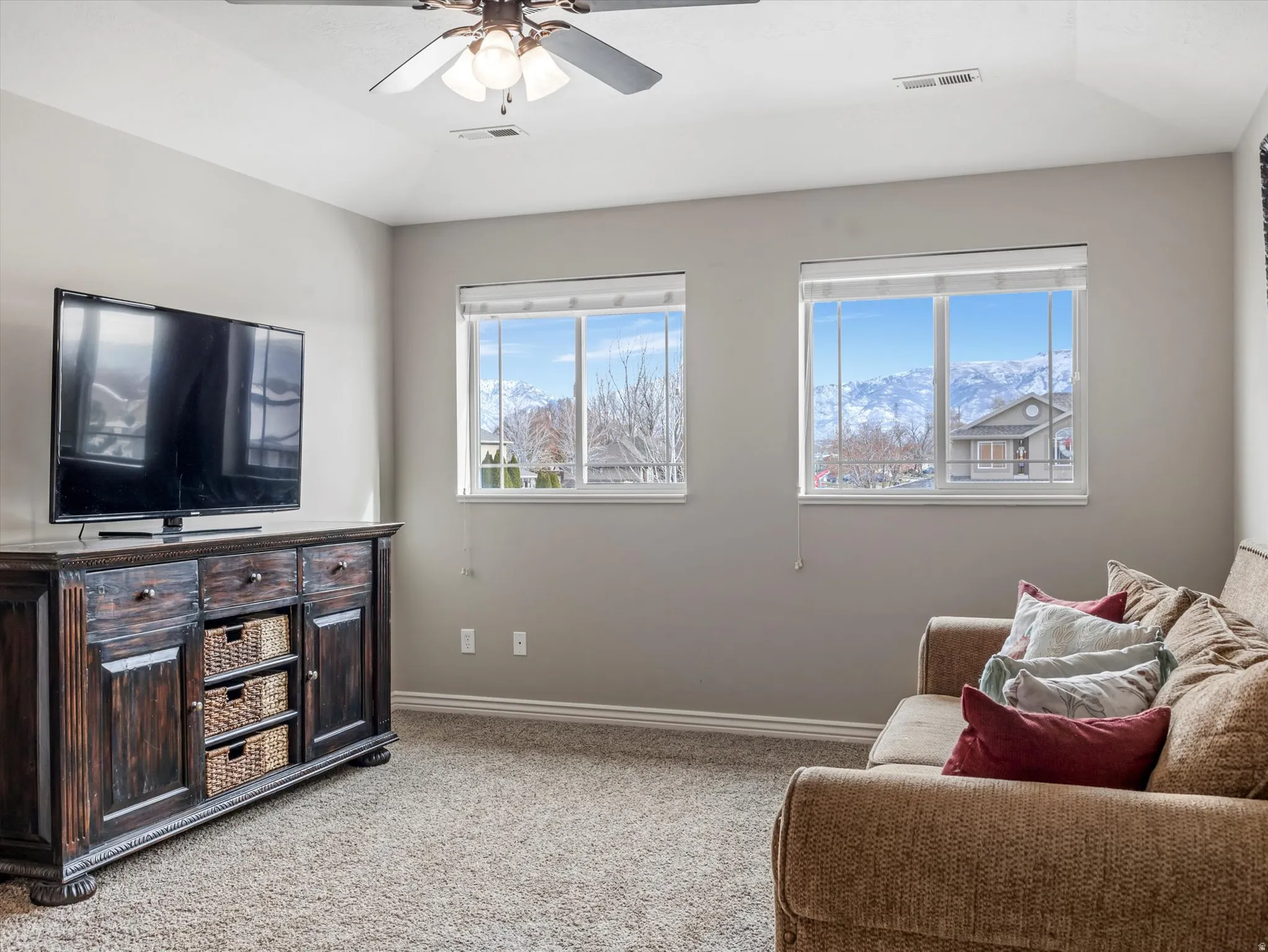 Living room with light colored carpet and a ceiling fan