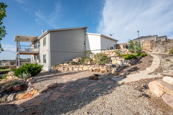 View of side of property featuring stucco siding and a balcony