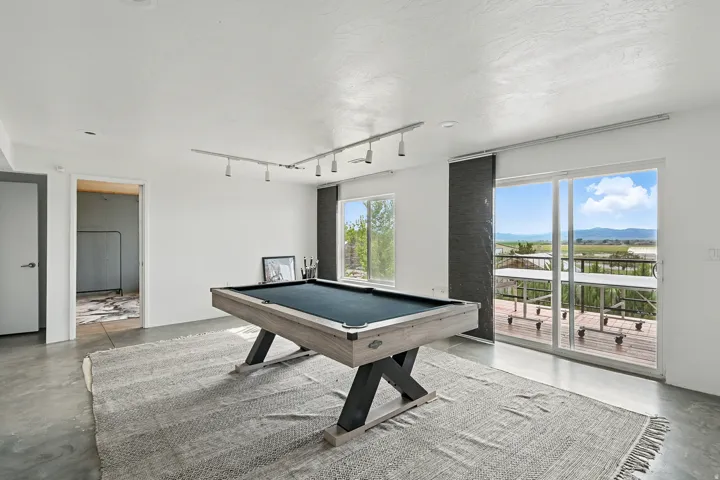 Recreation room featuring concrete floors, pool table, rail lighting, a mountain view, and a textured ceiling