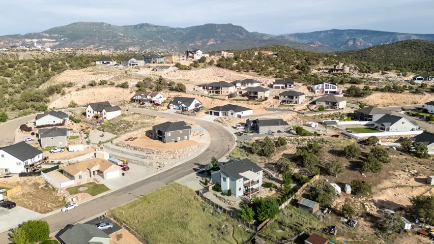 Aerial view of property's location with nearby suburban area and a mountainous background