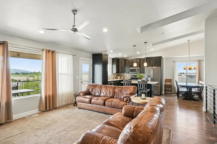 Living room with vaulted ceiling, a ceiling fan, and recessed lighting