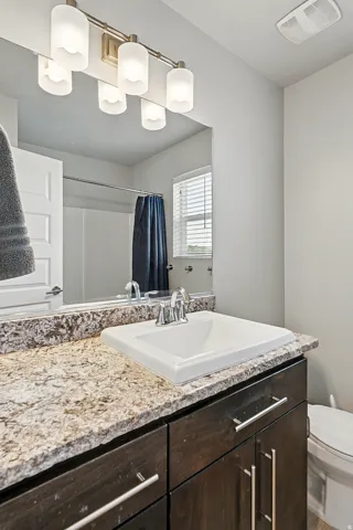 Bathroom with a shower with shower curtain and vanity
