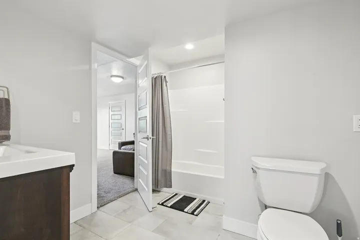 Full bath with vanity, shower / bathtub combination with curtain, and light tile patterned floors