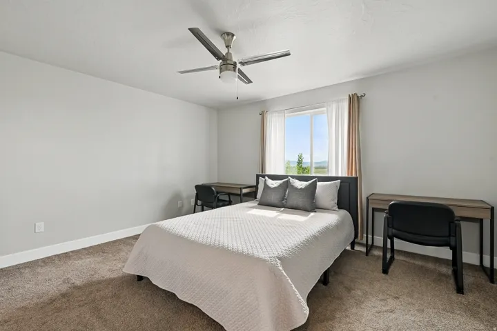 Bedroom featuring light colored carpet and ceiling fan