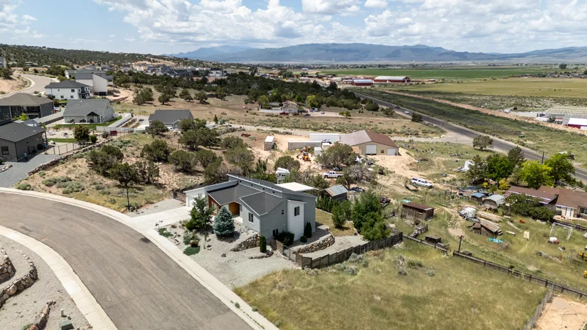 Aerial view of property's location with a mountainous background and nearby suburban area