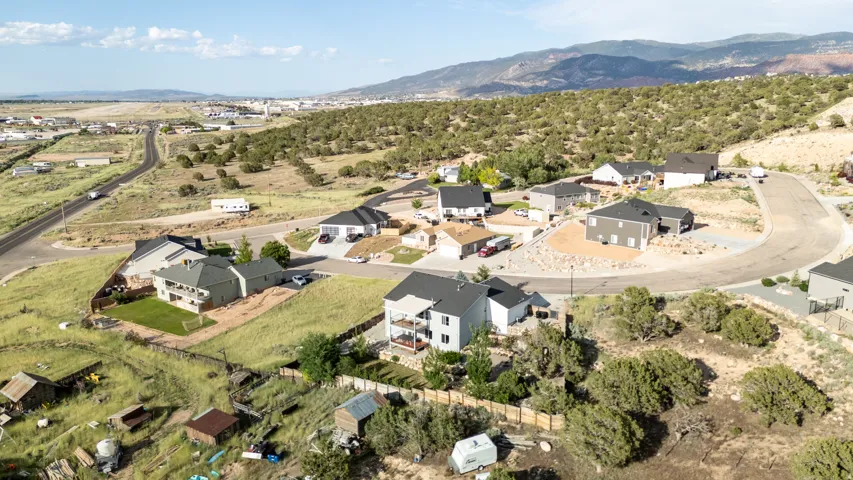 Aerial view of property and surrounding area featuring nearby suburban area