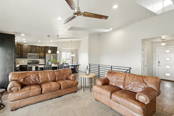 Living area featuring lofted ceiling, ceiling fan, and recessed lighting