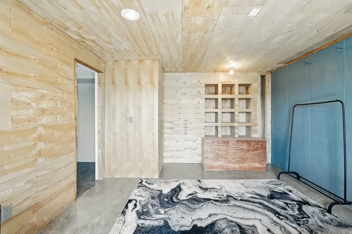 Unfurnished bedroom featuring wood walls, concrete flooring, and wooden ceiling