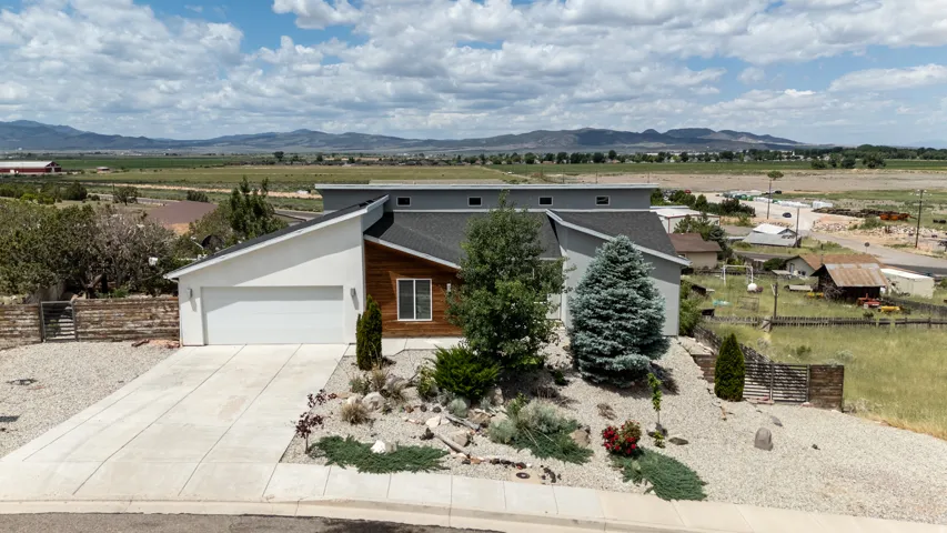 View of front facade with concrete driveway, a mountain view, and a garage