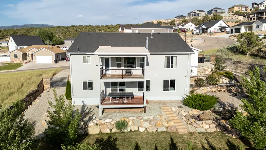 Rear view of house with a balcony, a residential view, and a deck