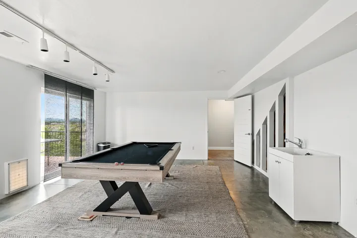 Recreation room with track lighting, billiards, and concrete flooring