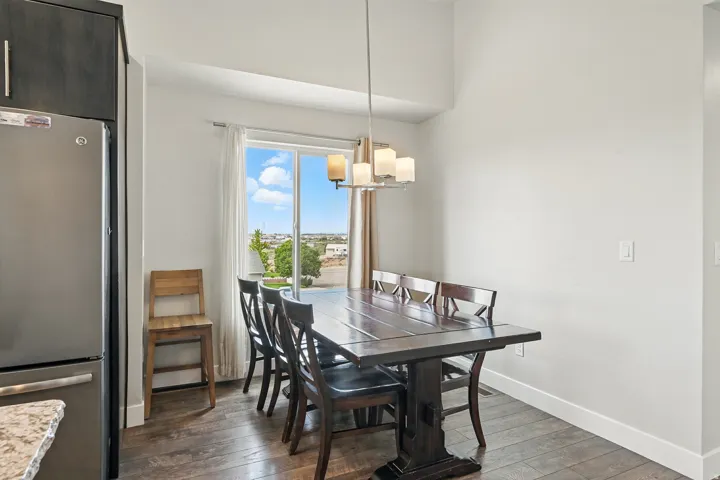 Dining area with dark wood-type flooring and a chandelier