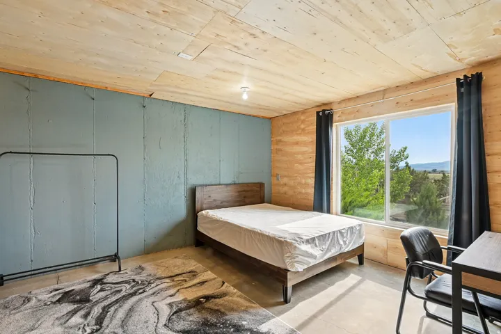 Bedroom featuring concrete flooring and wood ceiling