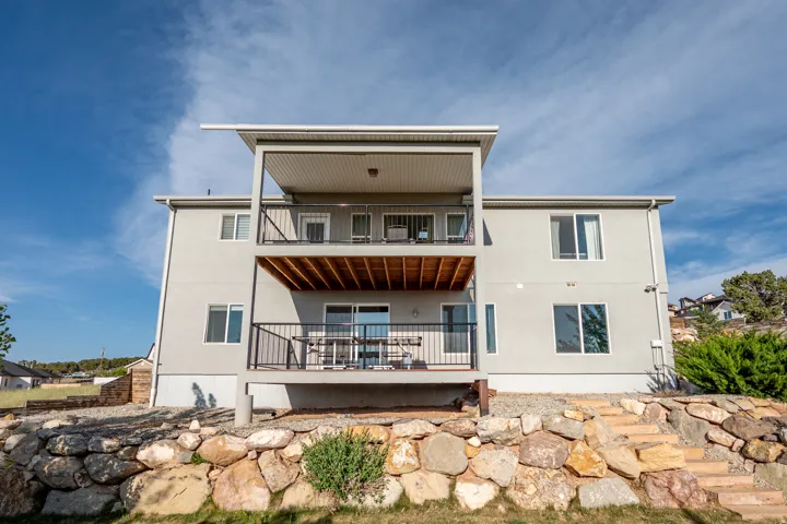 Back of property featuring a balcony and stucco siding
