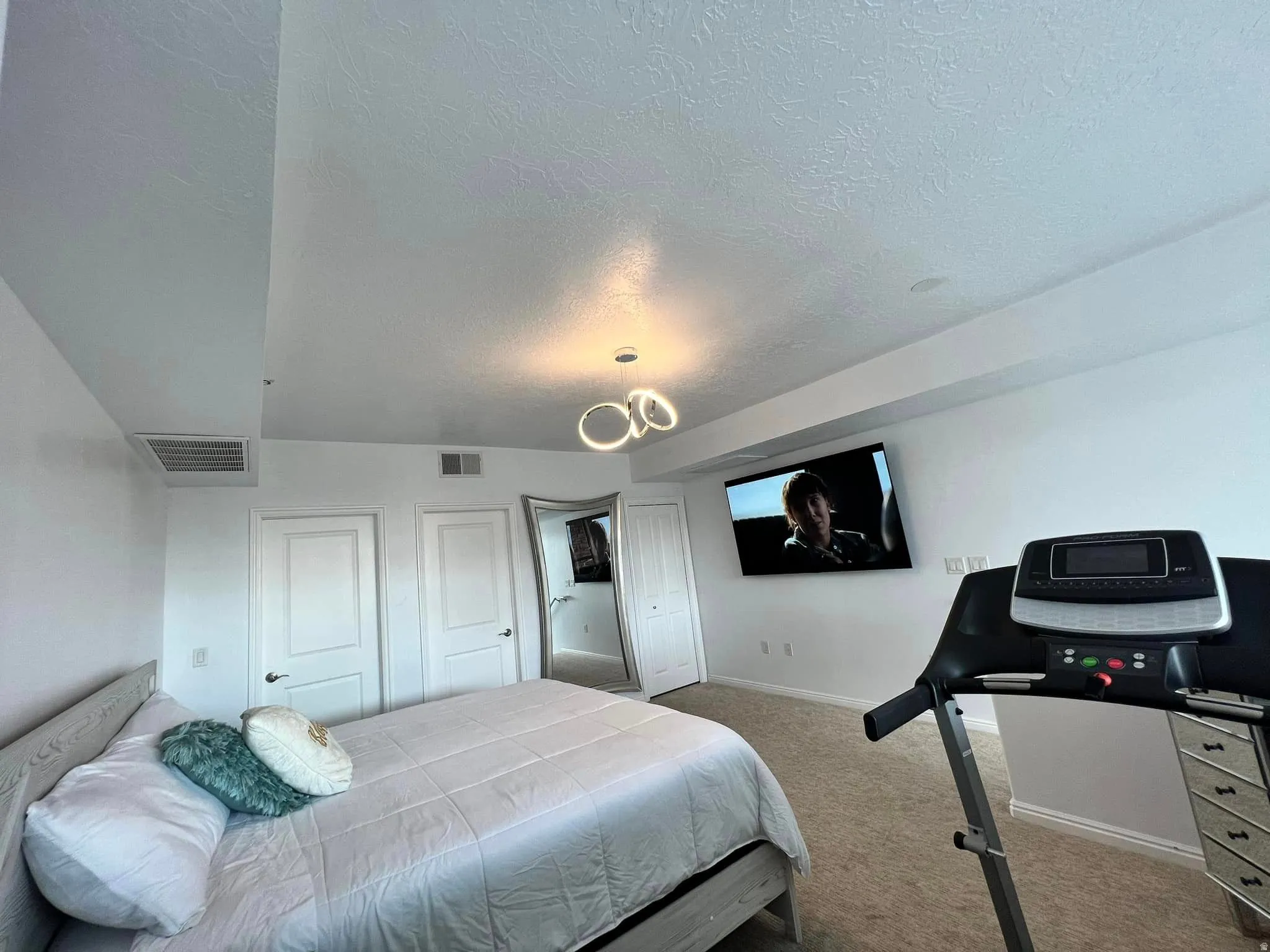 Bedroom featuring light carpet and a textured ceiling