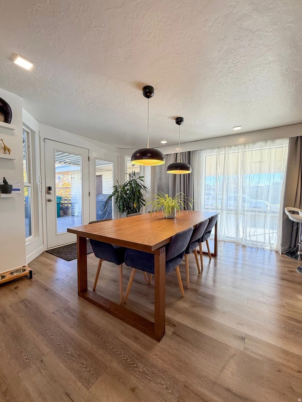 Dining room with light wood finished floors and a textured ceiling