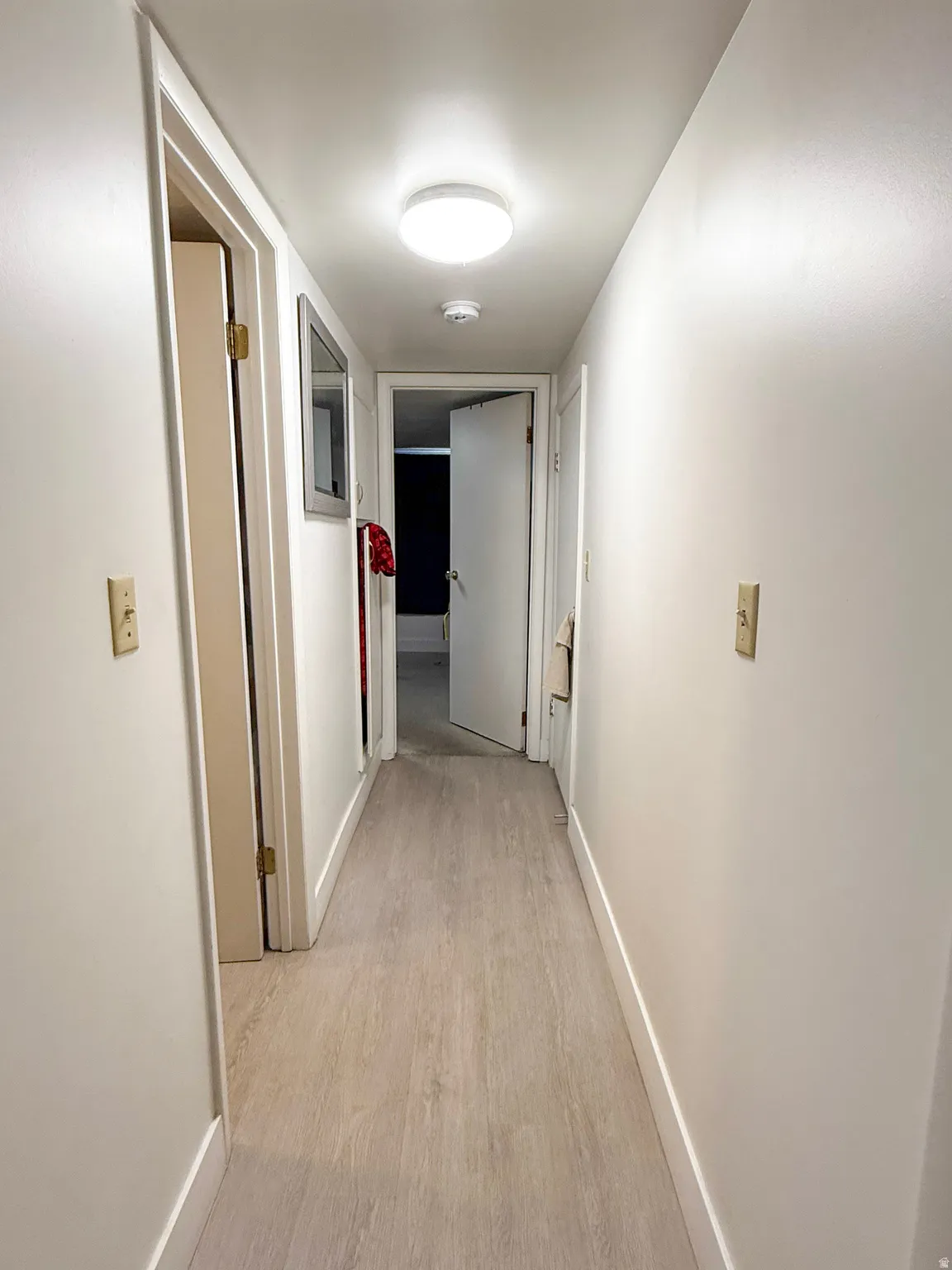 Corridor with baseboards and light wood finished floors