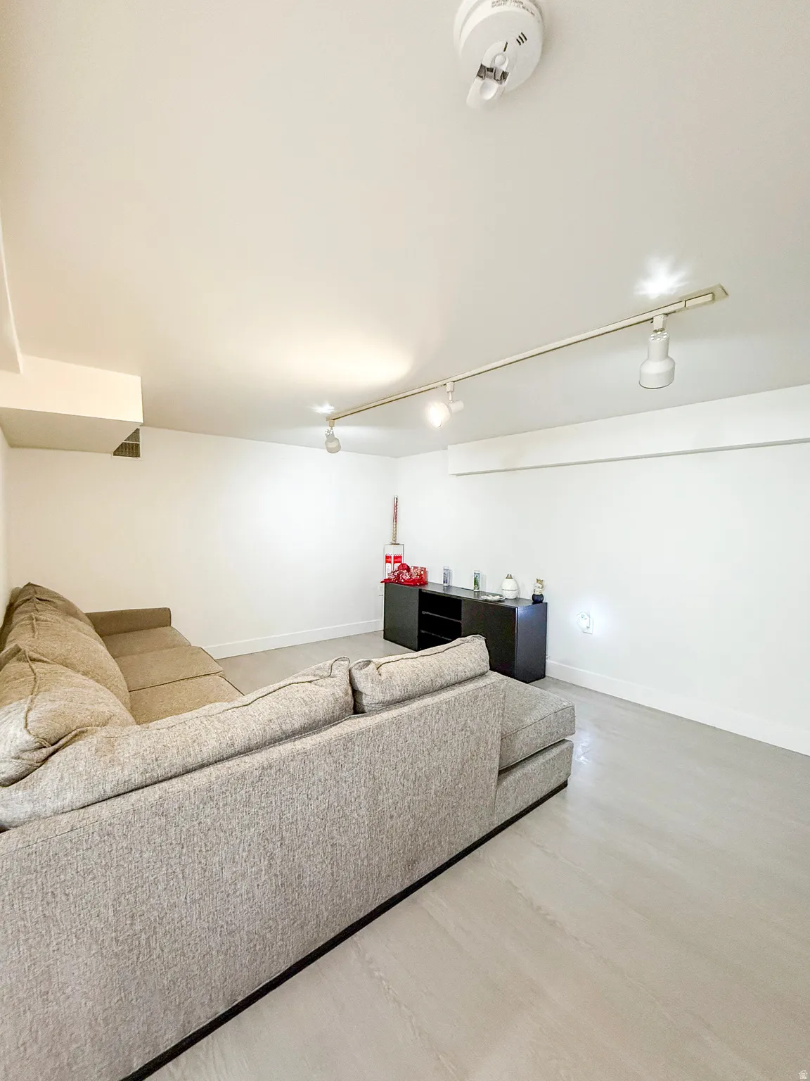 Living room with rail lighting and baseboards