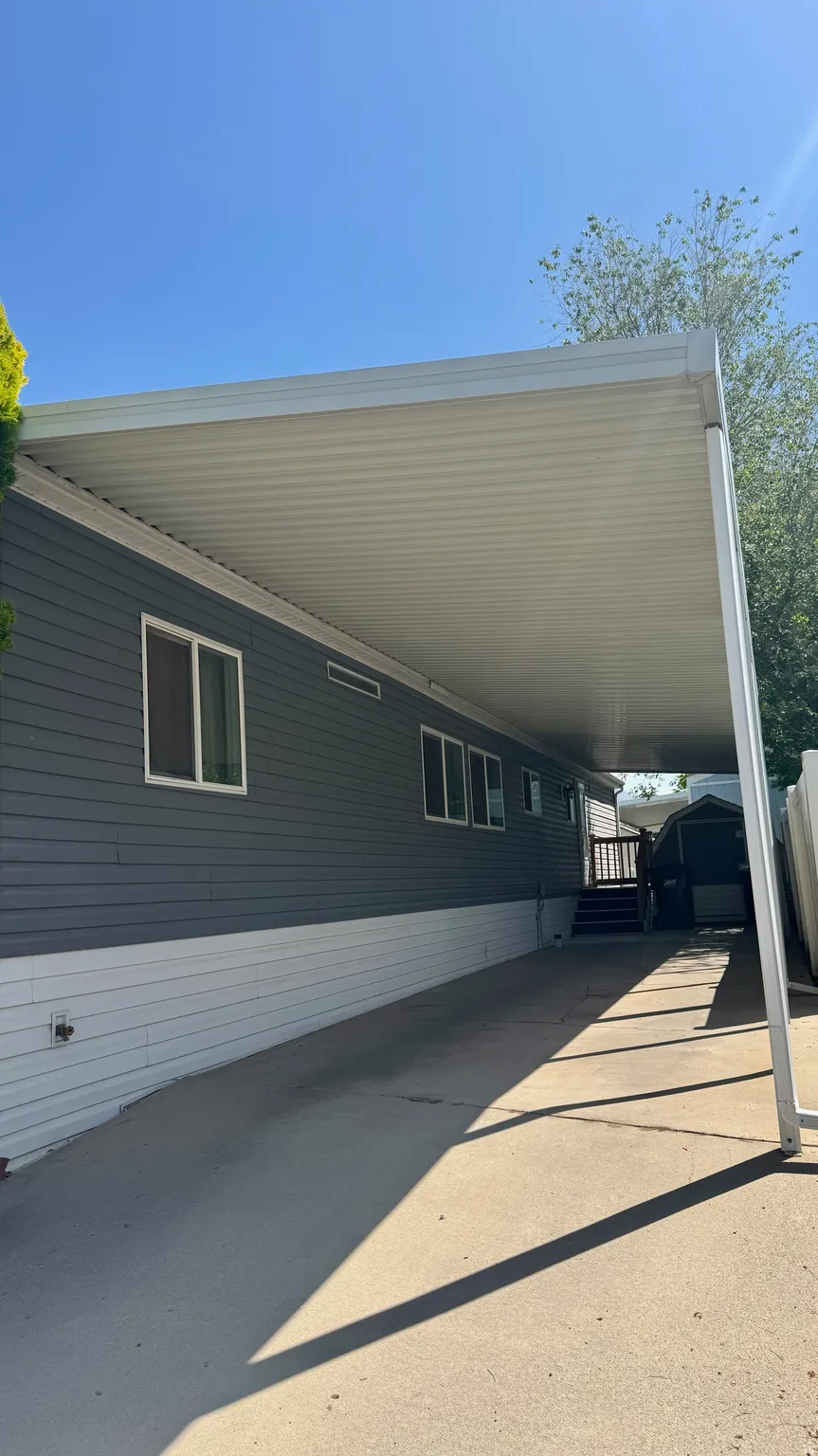View of home's exterior with a carport and a storage unit