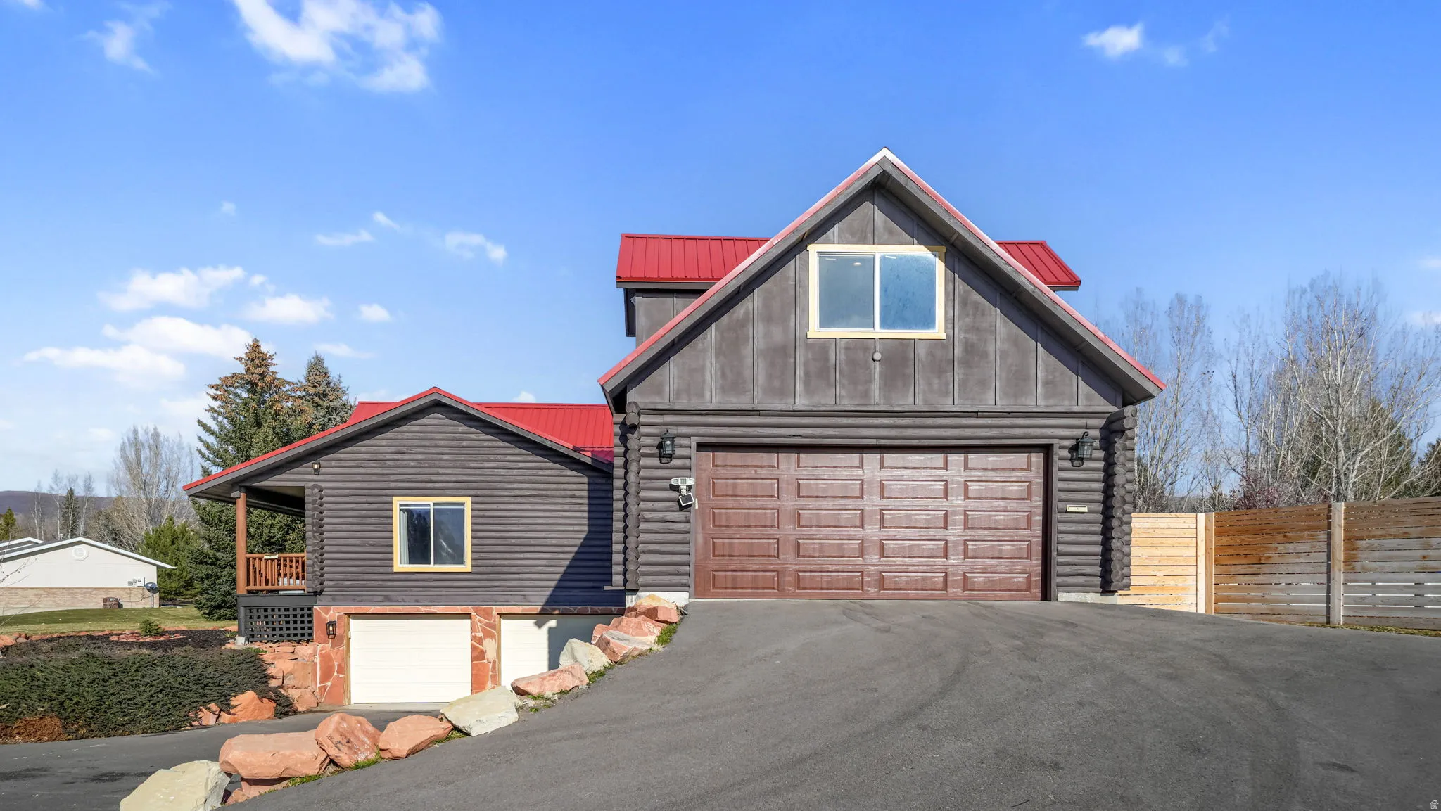 View from side. With 2 single car and 1 double wide 2 car garage, asphalt driveway