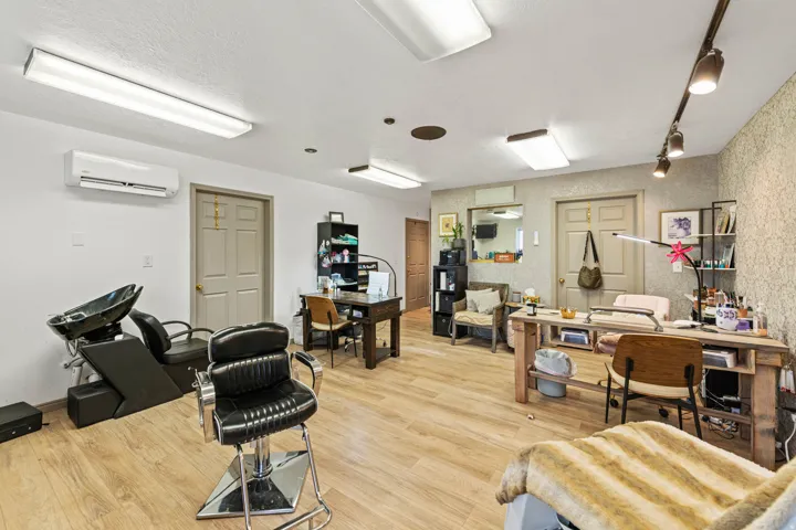 Office space featuring light wood-style flooring, a wall unit AC, and track lighting
