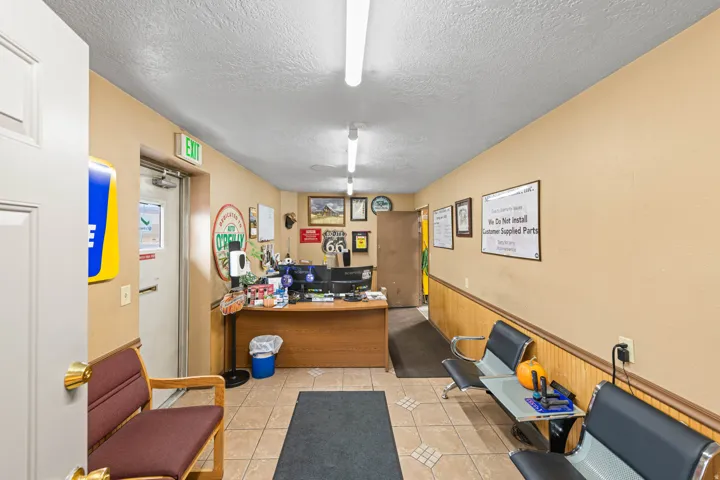 Office area with wainscoting, a textured ceiling, and wood walls