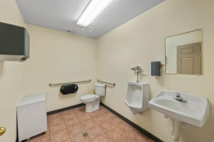 Bathroom featuring light tile patterned floors and a textured ceiling