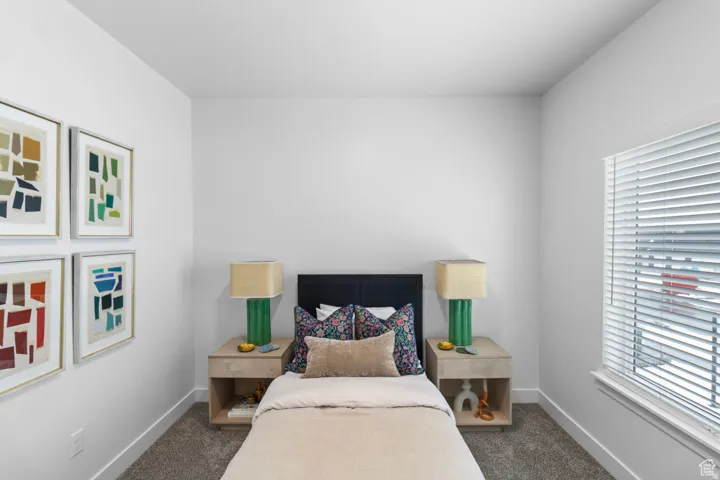 Bedroom with dark carpet and baseboards