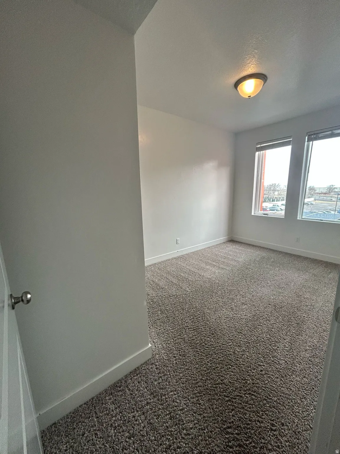 Carpeted spare room with baseboards and a textured ceiling