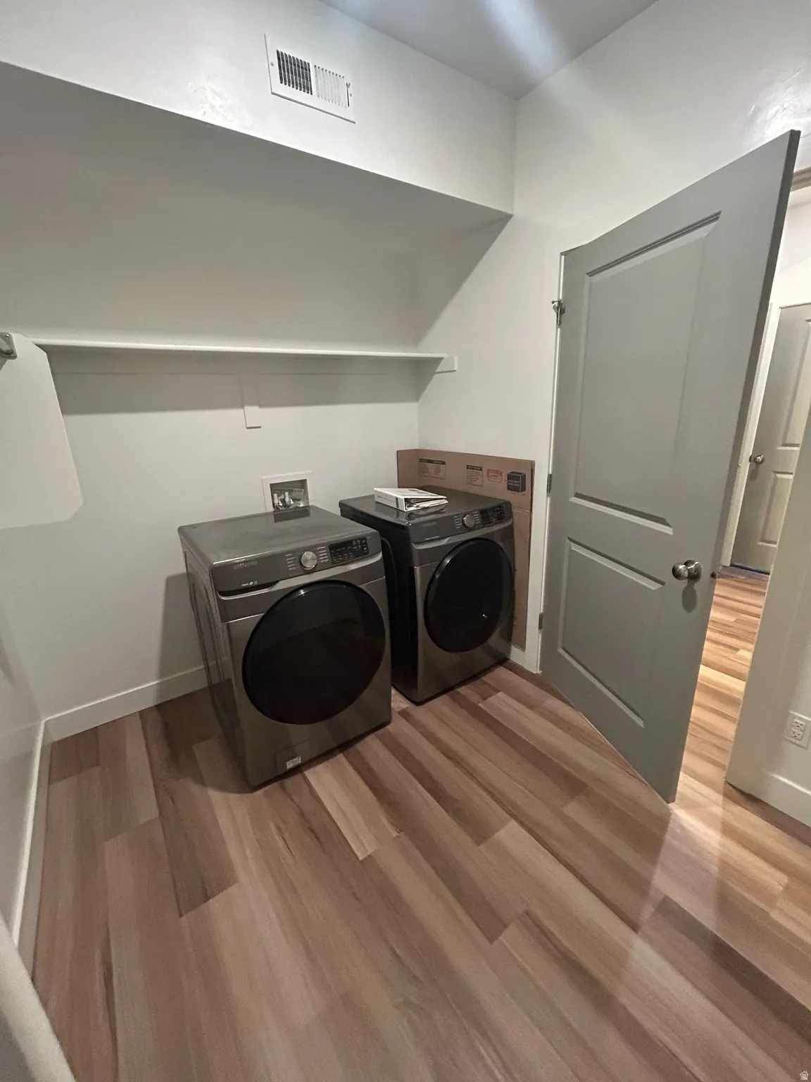 Laundry area featuring light wood-style floors and washer and dryer
